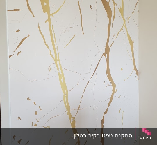טפט עם דוגמת שיש זהב על קיר לבן